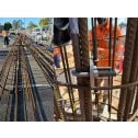A montage of two images showing the splicing u-bolt assembled and attached to a large pile cage ready to be lowered into position.