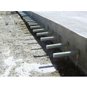 Construction of a pavement extension showing round dowel bar protruding from the side of concrete slab.